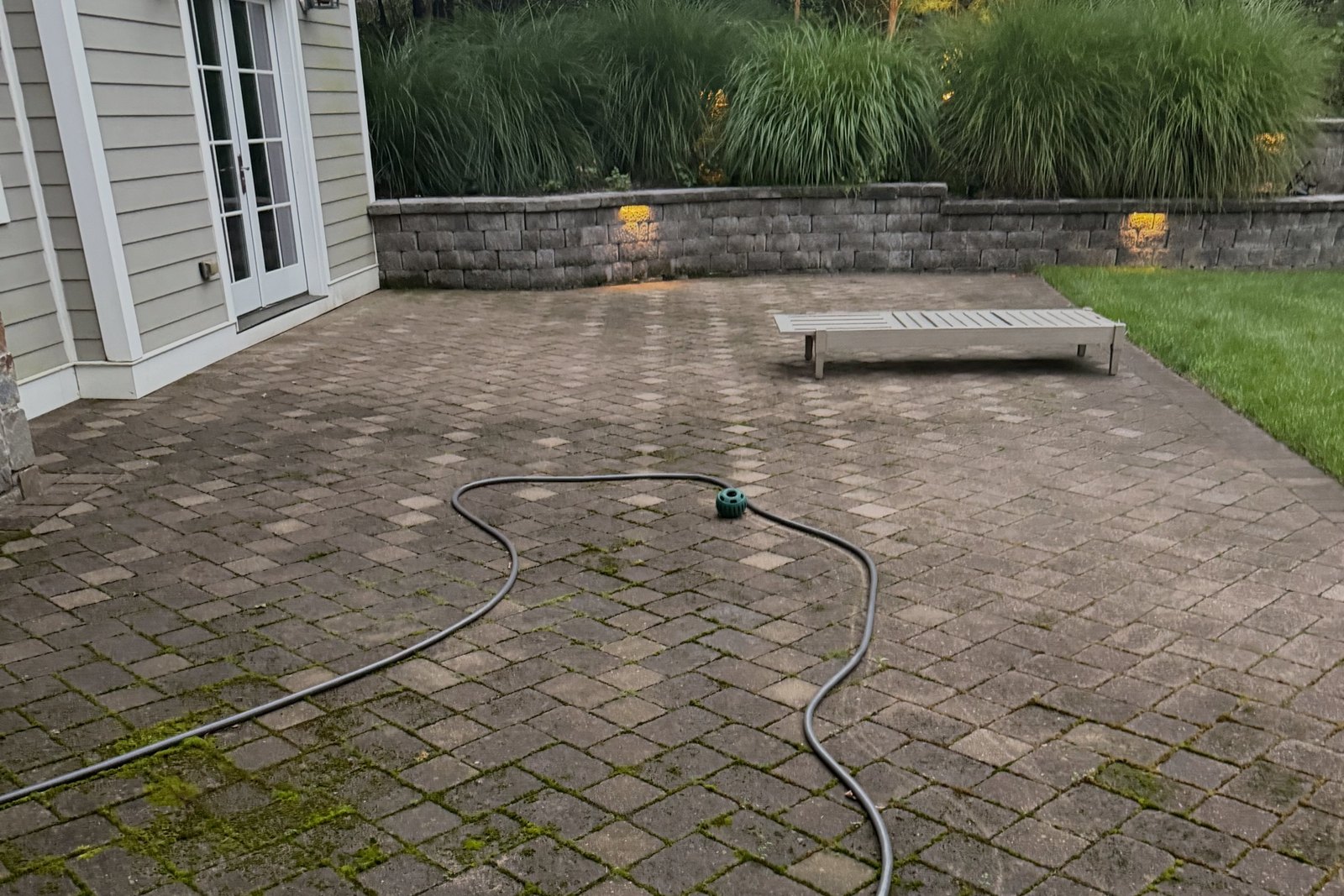 Mossy interlocking paver patio before pressure washing
